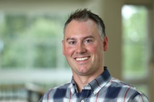 A man, Kelly Wenig, smiling widely.