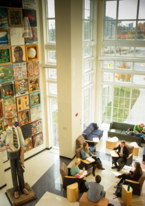 A group of students sitting together in a circle in a bright, welcoming meeting space.