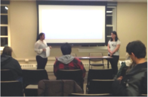 Two women in front of a lecture style classroom.