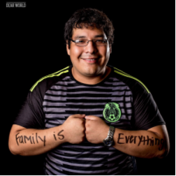 A smiling young man with text across his arms reading, "Family is everything."