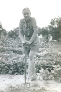 Black and white photo of a woman in a garden.