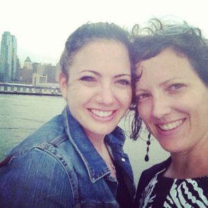 Current photo of sisters Billie (left) and Cydney (right), on board a boat with the New York City skyline behind them.