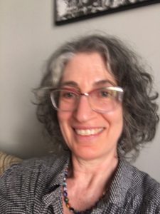 Shifra Sharlin smiles while wearing glasses.