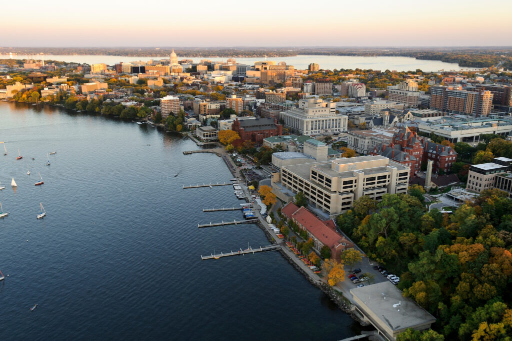 The Lake Mendota shoreline is pictured in an aerial view of the University of Wisconsin-Madison campus looking toward the downtown Madison skyline during an autumn sunset on Oct. 5, 2011. Major campus facilities pictured from center to right include Memorial Library, Armory and Gymnasium (Red Gym), the Memorial Union Terrace and Helen C. White Hall. On the horizon is the Wisconsin State Capitol and Lake Monona. The photograph was made from a helicopter looking southeast.