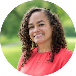 Gabrielle, a smiling woman with curly brown hair and light brown skin