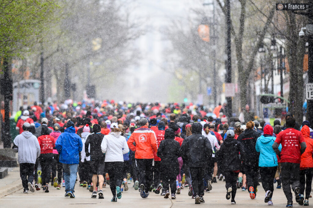 A large group of runners in lightly snowy weather