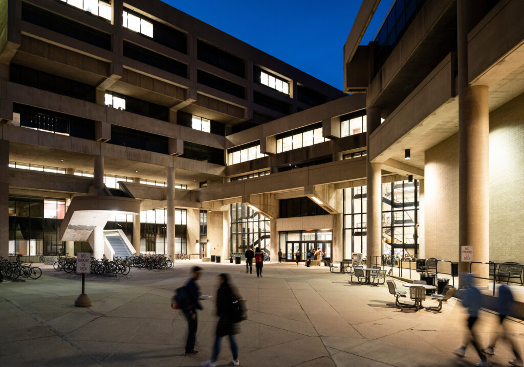 Busy evening scene of students passing through the front of Helen C. White Hall