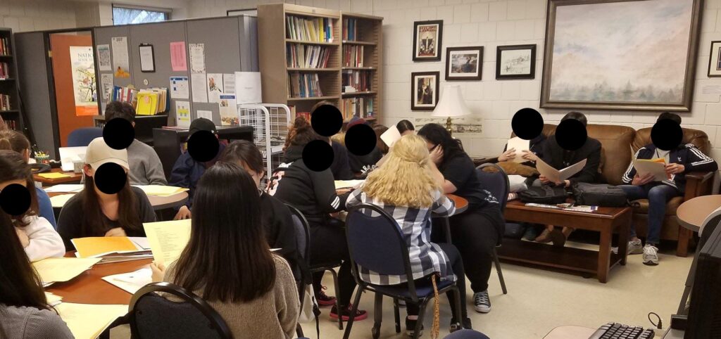 A crowded writing center space with students and tutors jammed closely together.