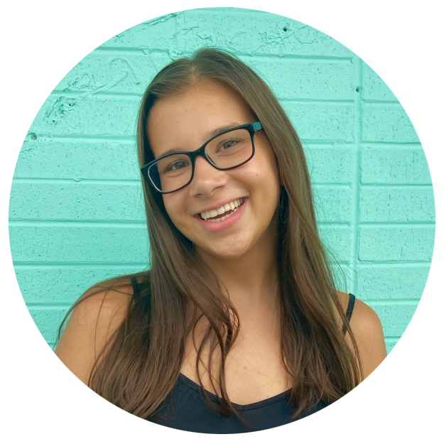 Miranda Parrish smiles in front of a bright teal wall.