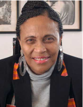 a close-up of Geneva Smitherman smiling and wearing large hoop earrings