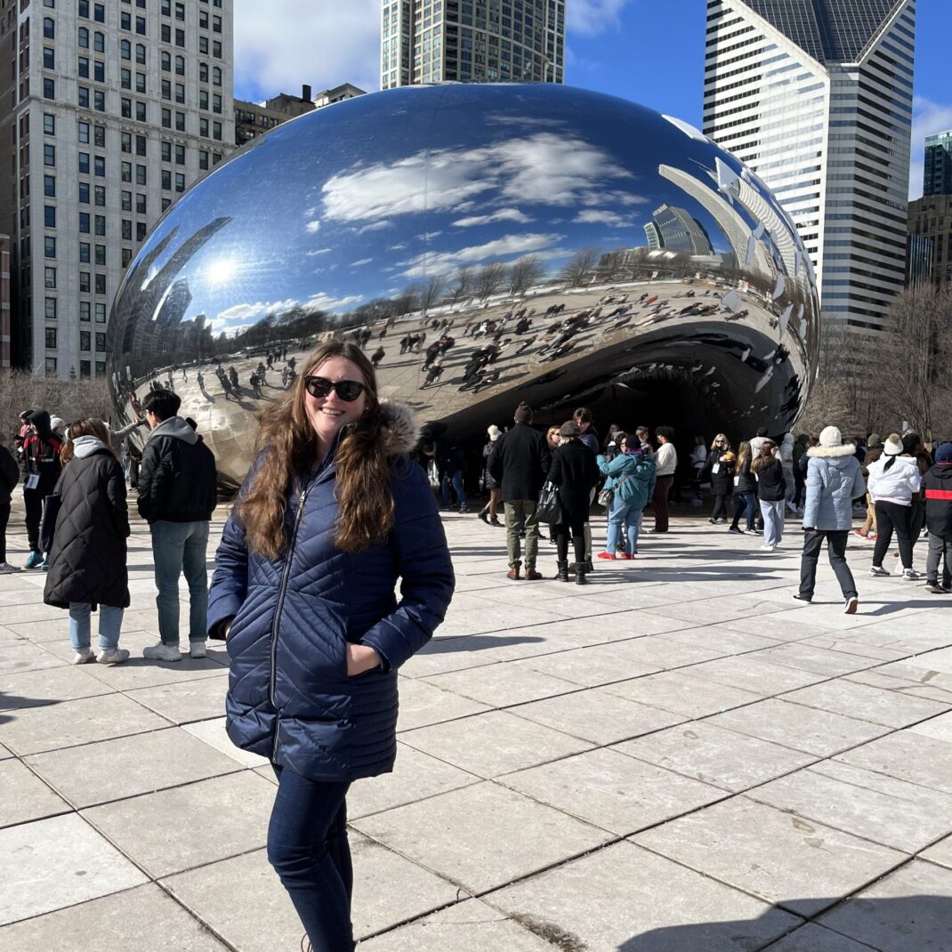 Ellen Cecil-Lemkin stands in front of the "bean" sculpture (Cloud Gate by Anish Kapoor) in Chicago's Millennium Park.