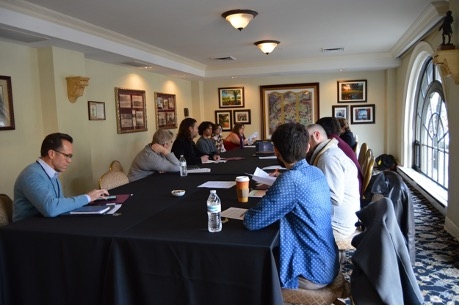 Participants seated at a table at the SLAC-WPA conference listen to the documentary created by Lafayette students about the College Writing Program on campus.