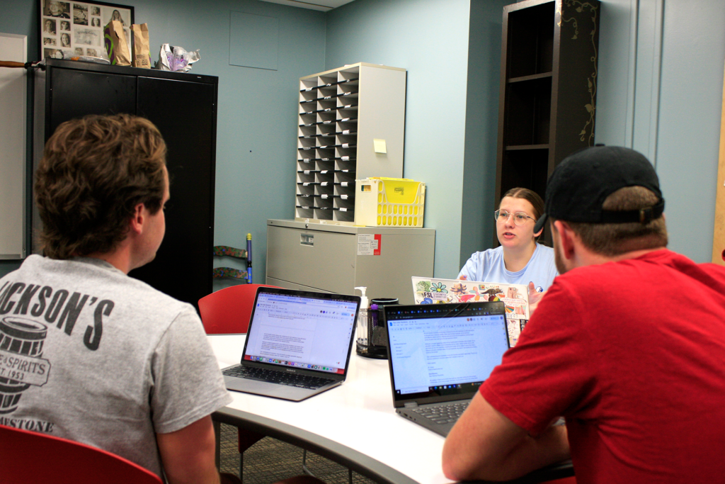 Students work together on small group assignments with a writing center staffer.