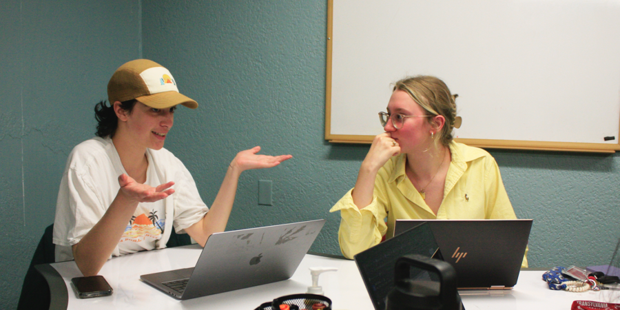 Writing center staffer gives feedback to a small writing group.