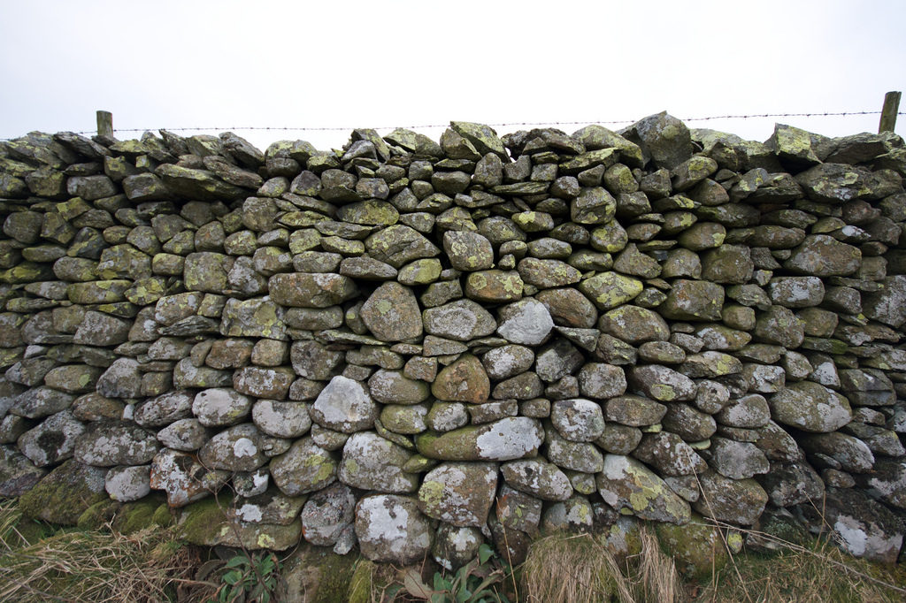 stone wall with barbed wire across the top, from http://www.flickr.com/photos/binaryape/3314028850/